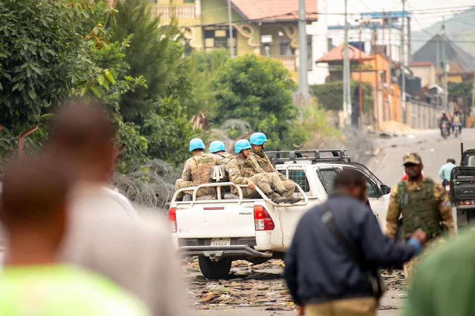 UN peacekeepers patrol a street in an urban setting, depicted with soldiers in blue helmets.